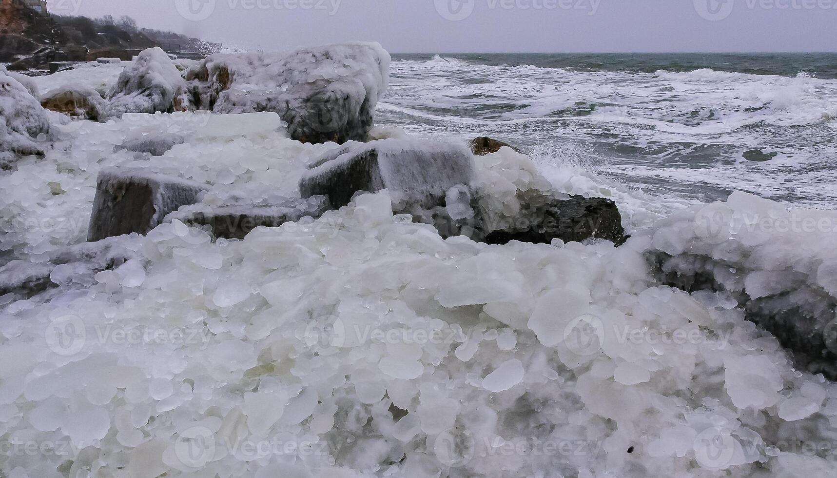 Frozen Black Sea, ice-covered and frozen coastal rocks in the piers, harsh winter photo