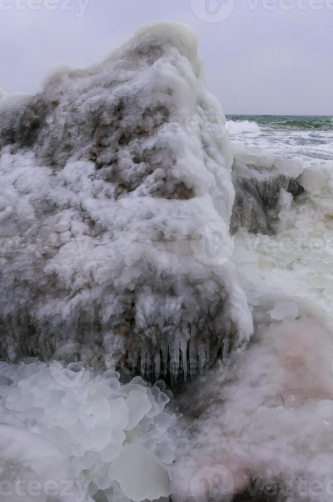 Frozen Black Sea, ice-covered and frozen coastal rocks in the piers, harsh winter photo