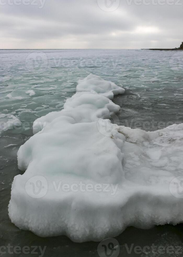 The Black Sea is frozen, ice floes float along the shore. Climate change, harsh winter photo