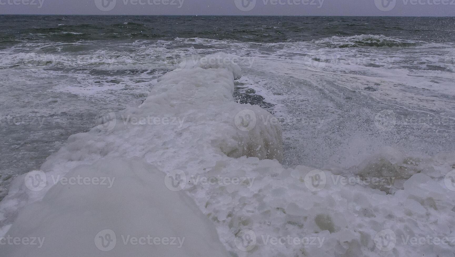 The Black Sea is frozen, the circular ice rolled by the waves is thrown ashore and frozen photo