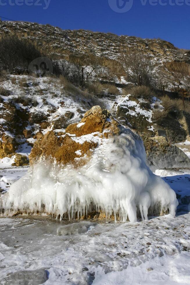 The Black Sea froze, ice covered the coastal stones. Climate change, harsh winter photo