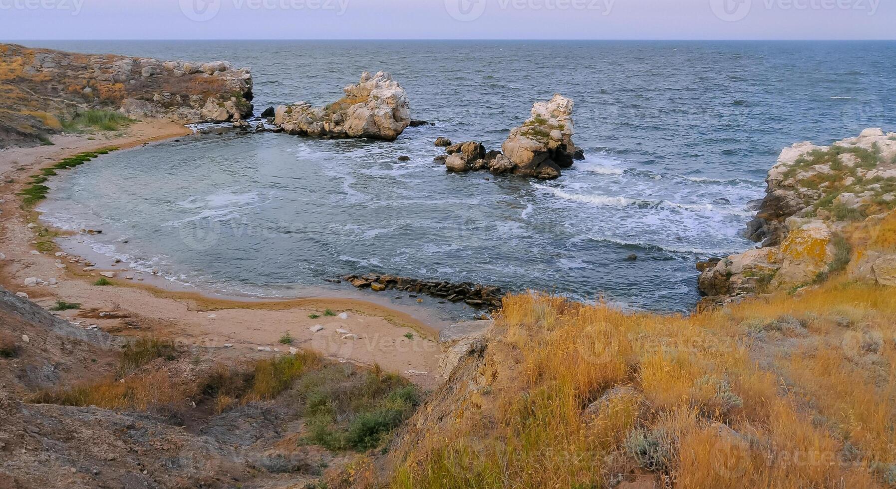 A small cozy sandy cove among the coastal rocks in the eastern Crimea, Kazantip, the Black Sea photo