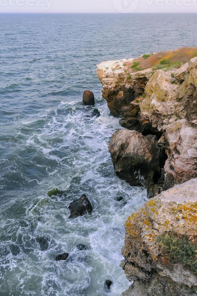 The steep stone coast of the Black Sea from Pontic limestones at Kazantip, Eastern Crimea photo