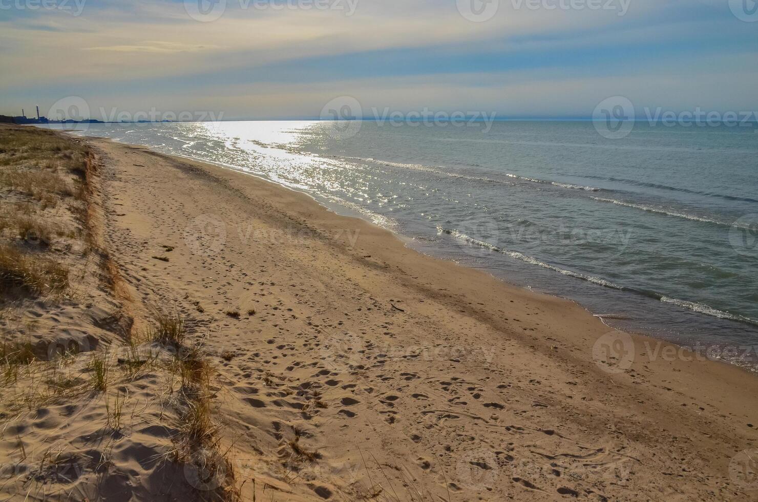 Sand dunes on the shore of a large lake, reflection of the sun in the water. Indiana Dunes National Lakeshore, USA photo