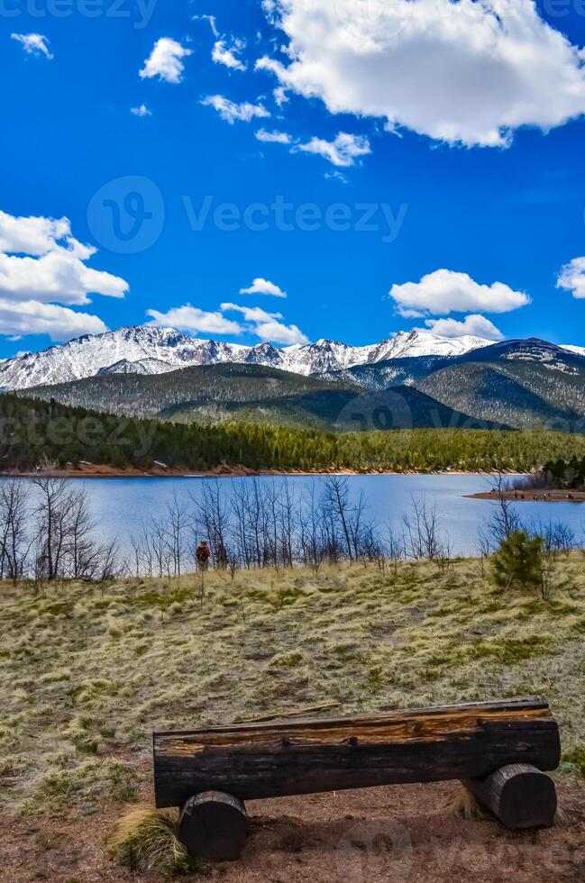 A tree trunk bench against the backdrop of the snow-capped Pikes Peak mountains, Colorado, US photo