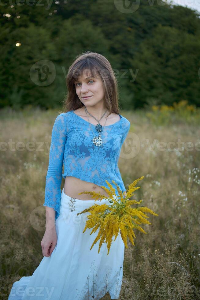 woman in whimsical aesthetic style dress in field in summer at sunset photo