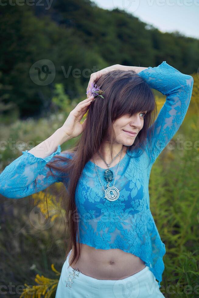 woman in whimsical aesthetic style dress in field in summer at sunset photo