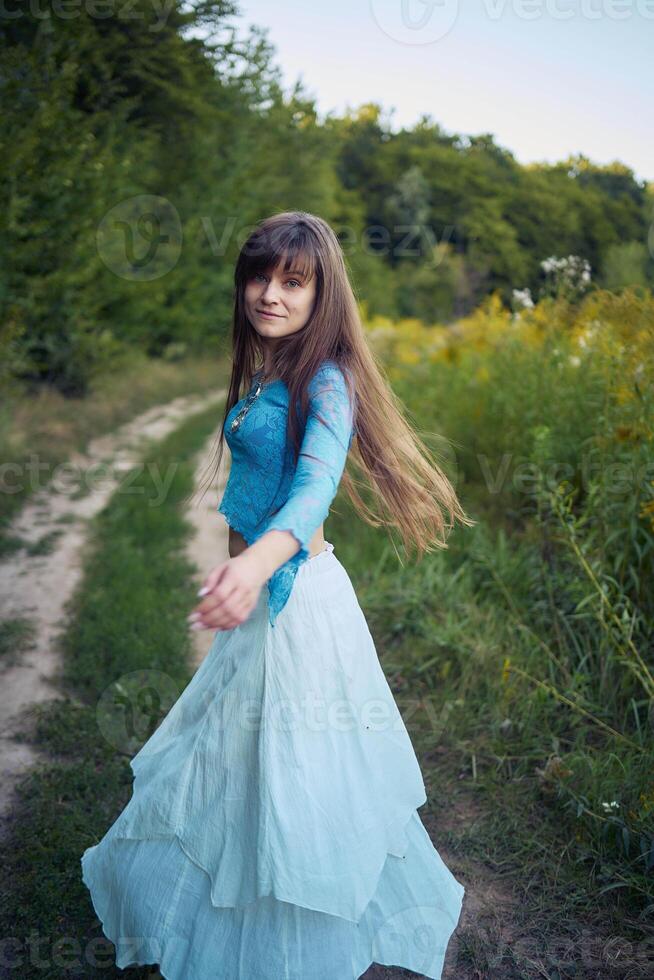 woman in whimsical aesthetic style dress in field in summer at sunset photo