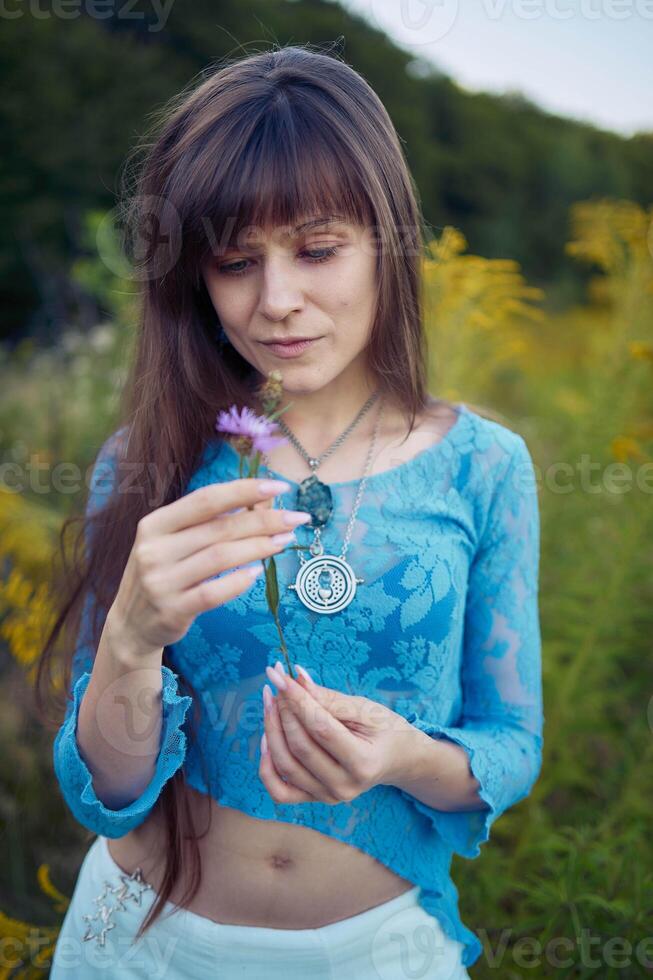 woman in whimsical aesthetic style dress in field in summer at sunset photo