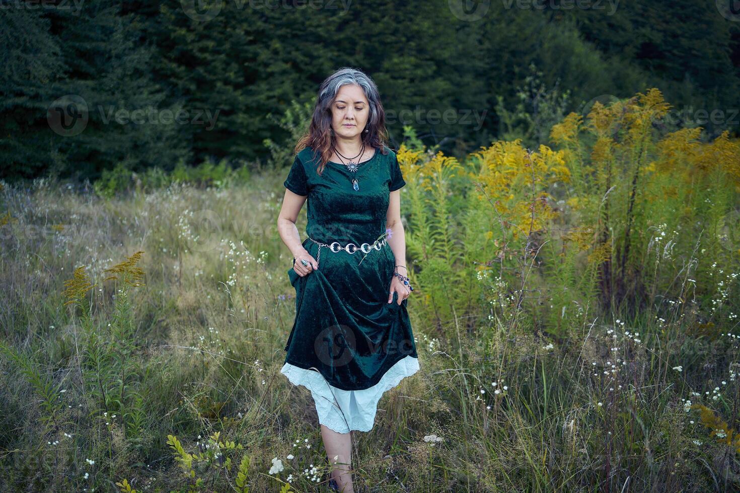 woman in whimsical aesthetic style dress in field in summer at sunset photo