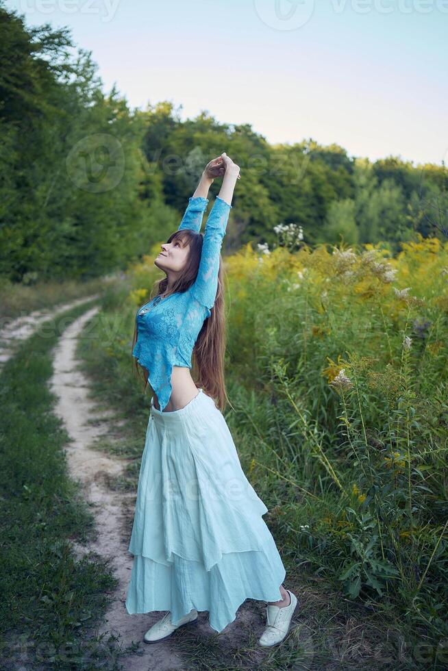 woman in whimsical aesthetic style dress in field in summer at sunset photo
