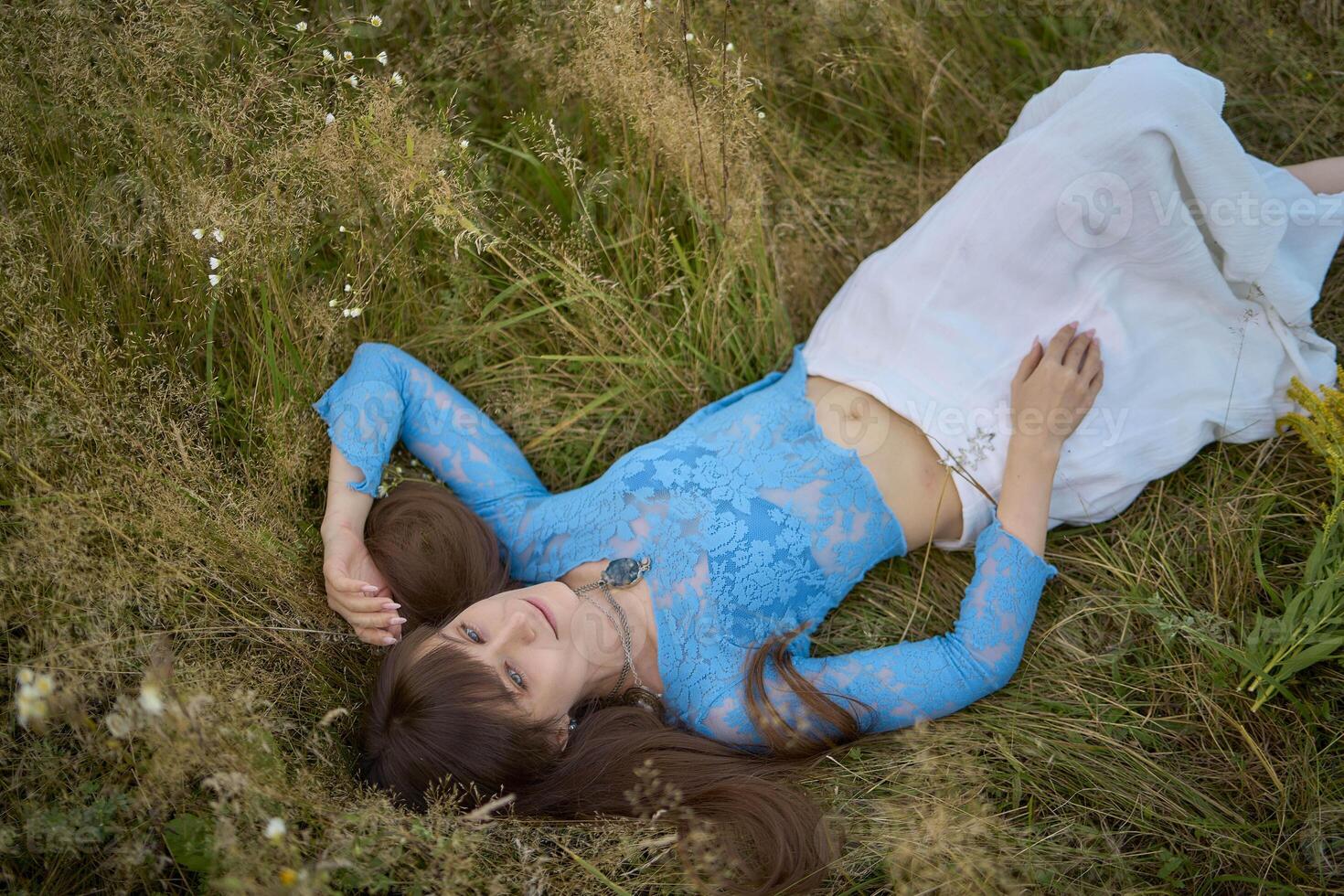 woman in whimsical aesthetic style dress in field in summer at sunset photo