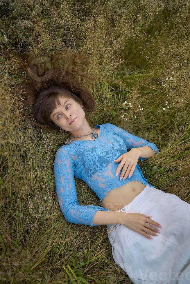 woman in whimsical aesthetic style dress in field in summer at sunset photo