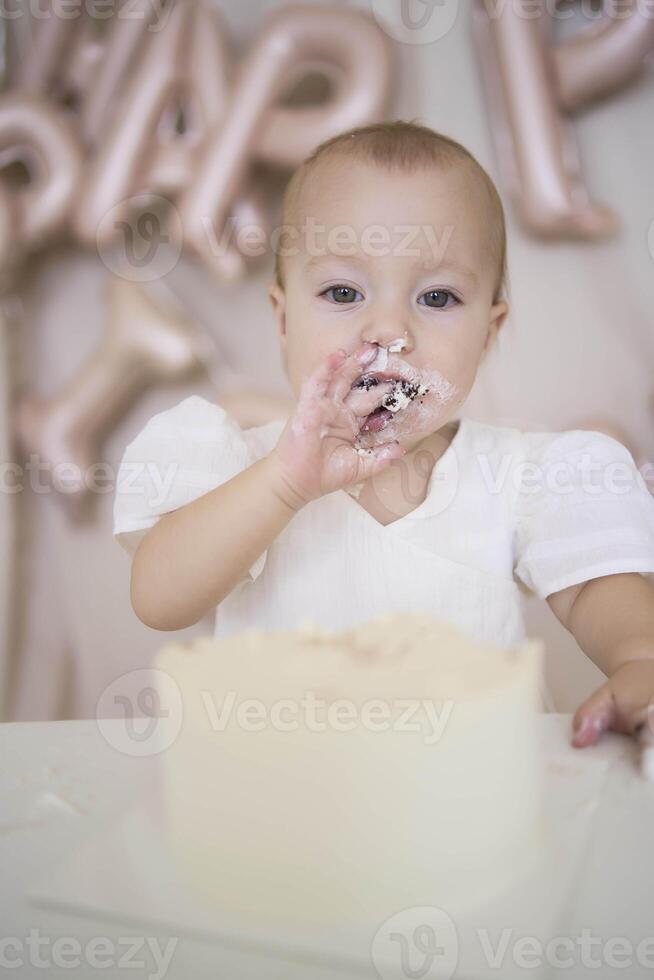 baby girl tries her first birthday cake with mom and pre-teen sister photo