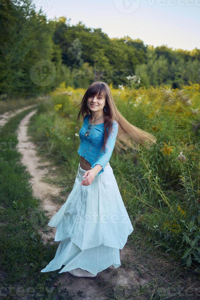 woman in whimsical aesthetic style dress in field in summer at sunset photo