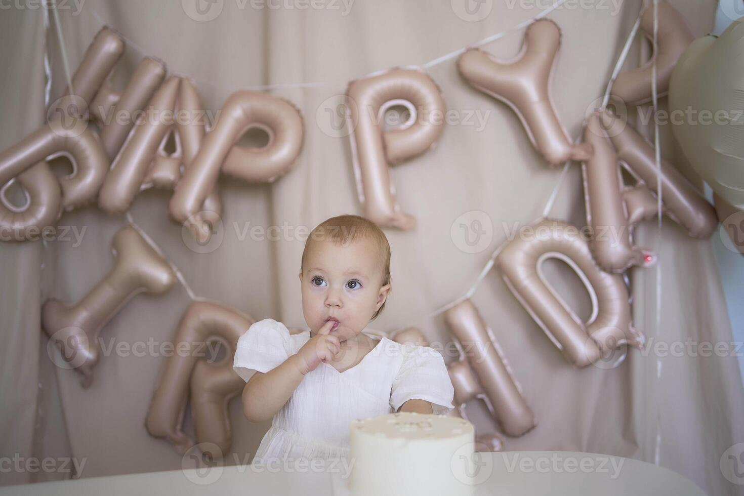 baby girl tries her first birthday cake with mom and pre-teen sister photo