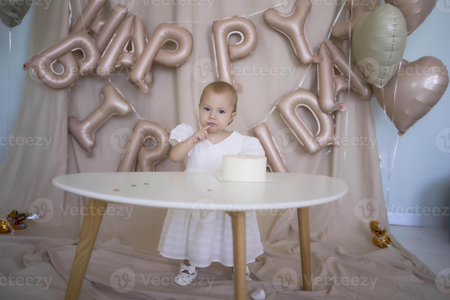 baby girl tries her first birthday cake with mom and pre-teen sister photo