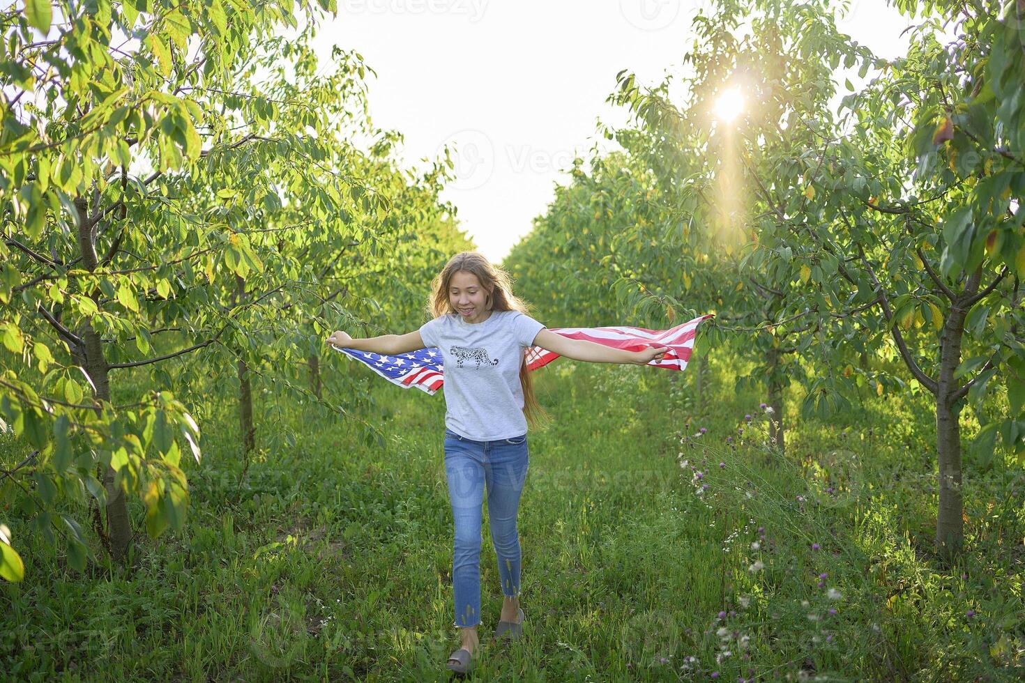 teenage girl running with american flag at independence day picnic photo