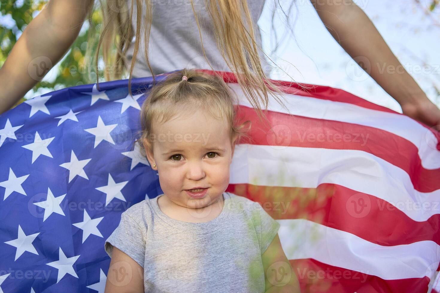 a toddler with american flag on independence day picnic photo