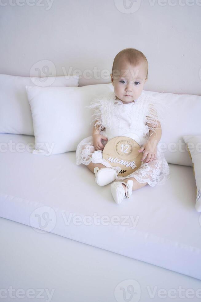 photo session on the first birthday of a baby girl, baby hold decor with writed 12 months in ukrainian language