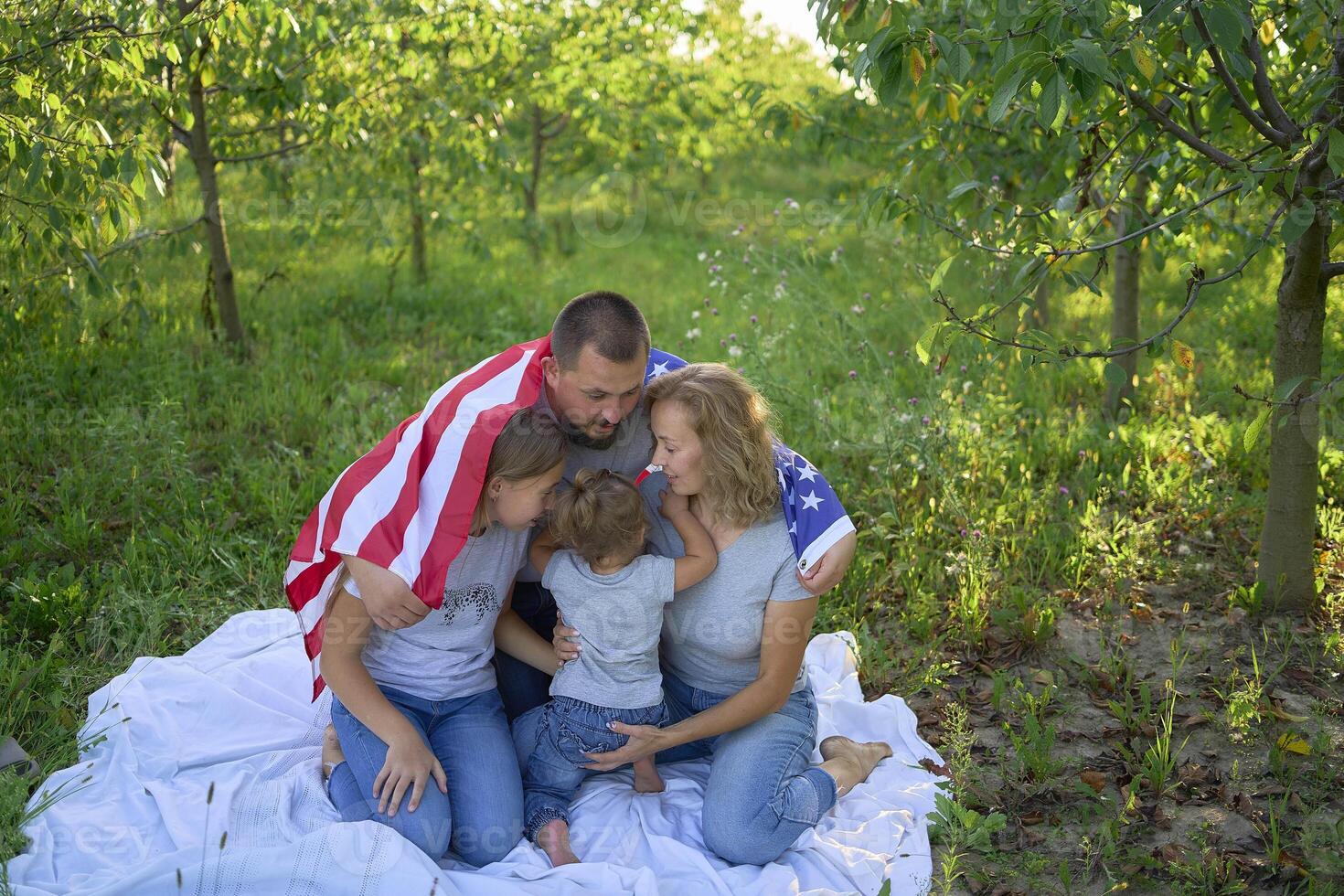 family on independence day picnic with american flag photo