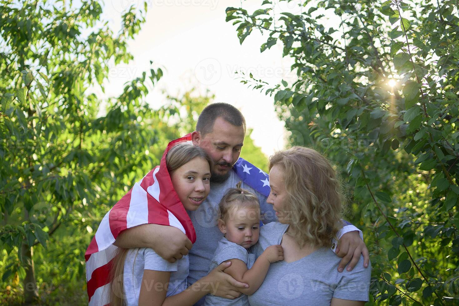 family on independence day picnic with american flag photo