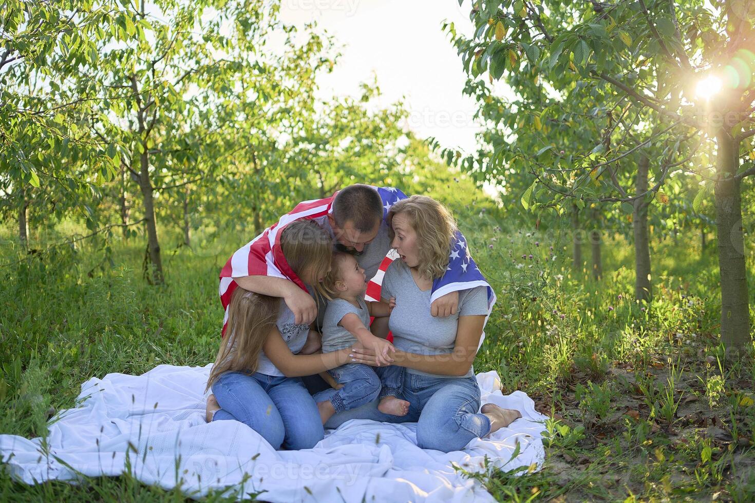 family on independence day picnic with american flag photo