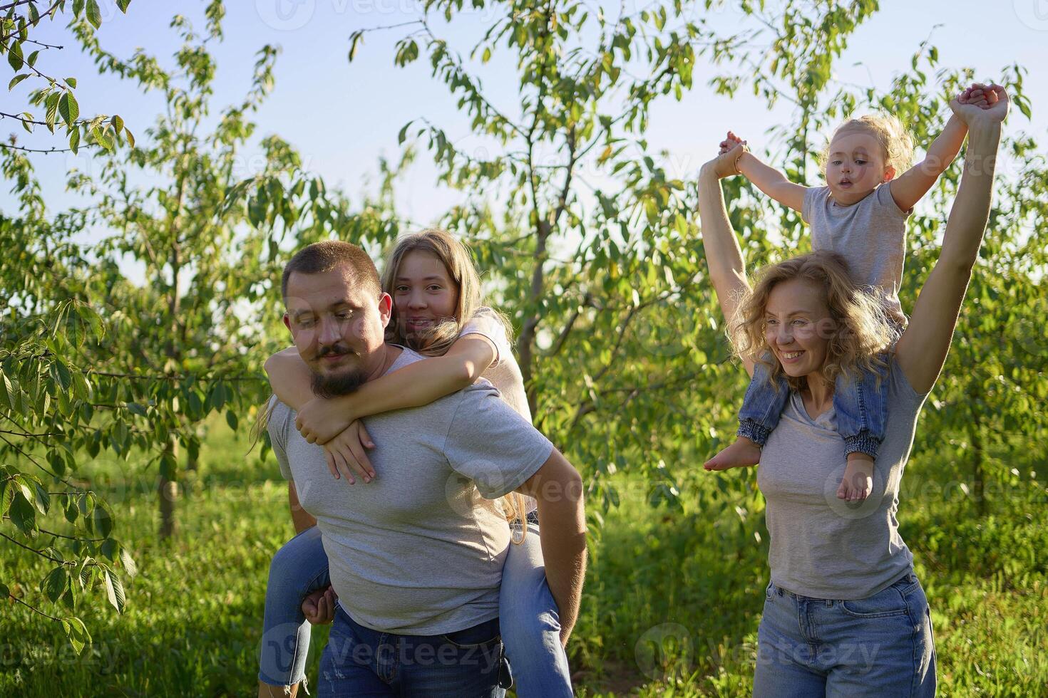 parents ride their children on their backs photo