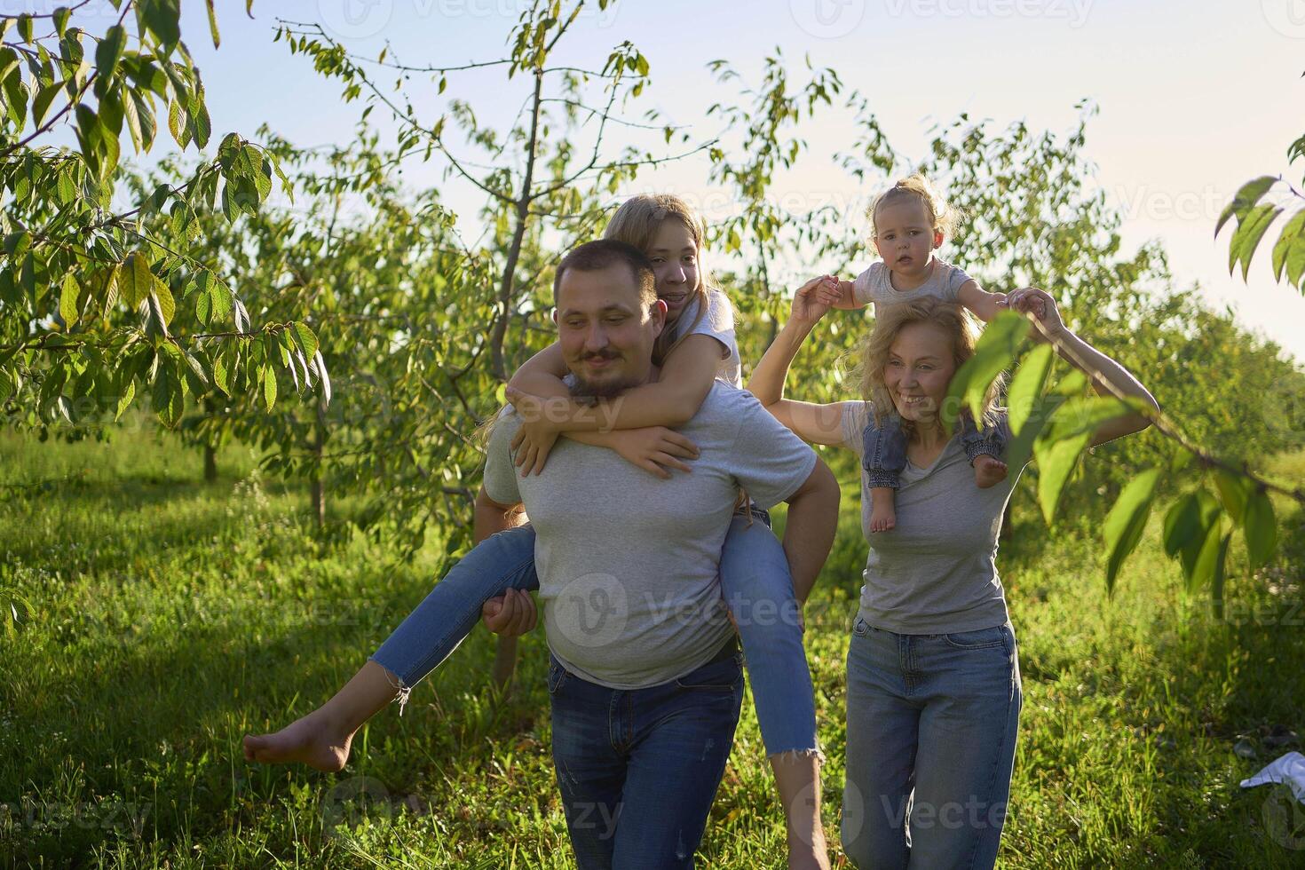 parents ride their children on their backs photo