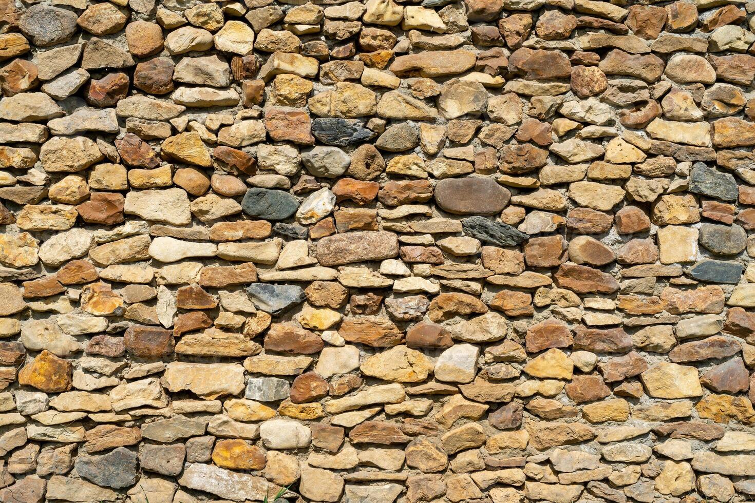 Wall of yellow stone. Abstract natural background. Uneven stone surface. photo