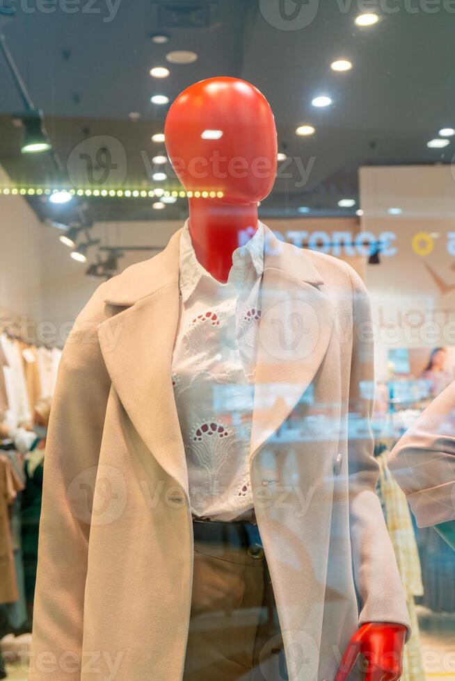 Red head dummy. Mannequin in the window of a supermarket clothing store. photo