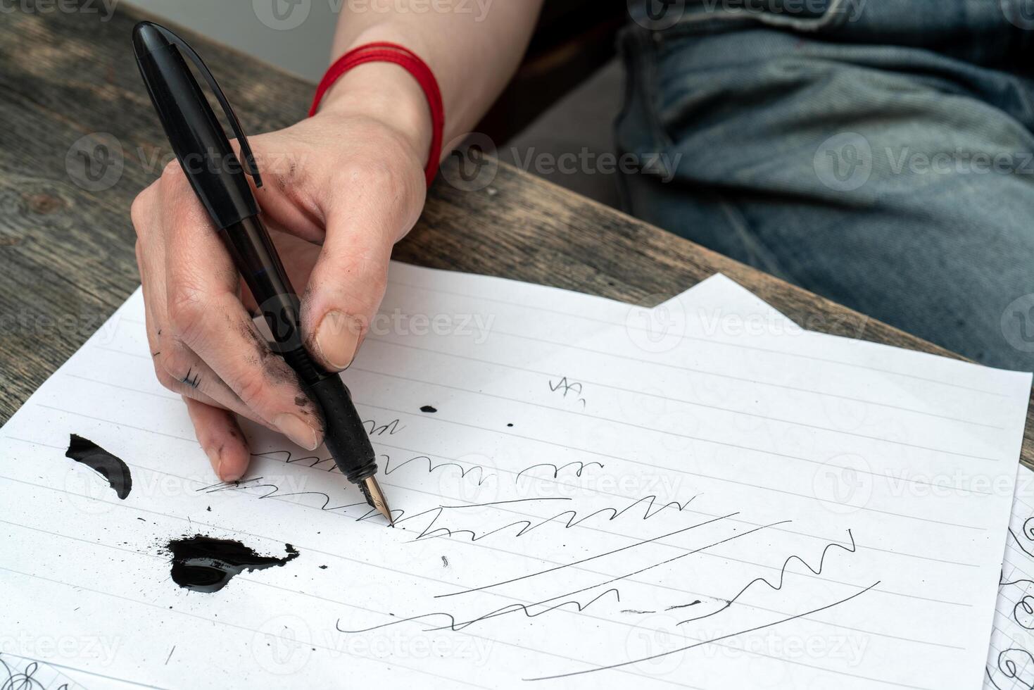 Calligraphy training. Fountain pen in ink-stained hands. photo