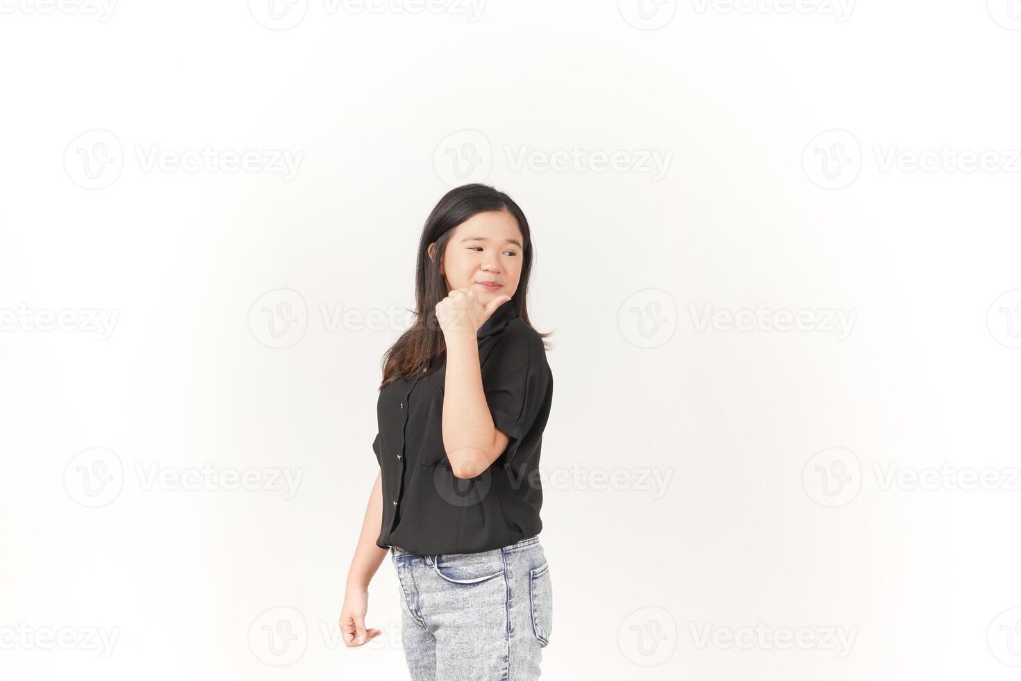 Young Asian woman pointing aside wall copy space wearing Black t-shirt and jeans isolated on white background photo