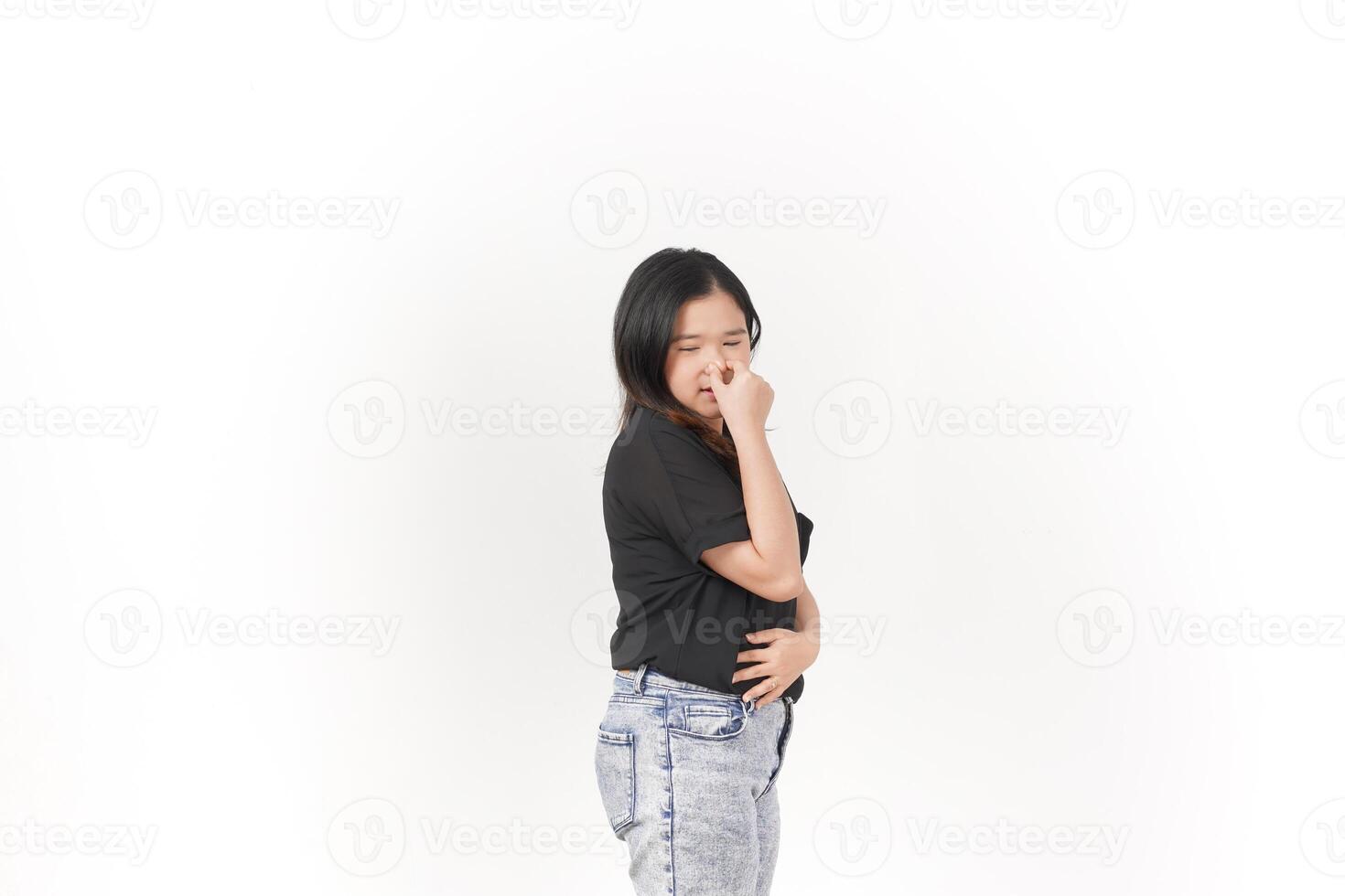 Young Asian woman Smelling something stinky and disgusting wearing Black t-shirt and jeans isolated on white background photo