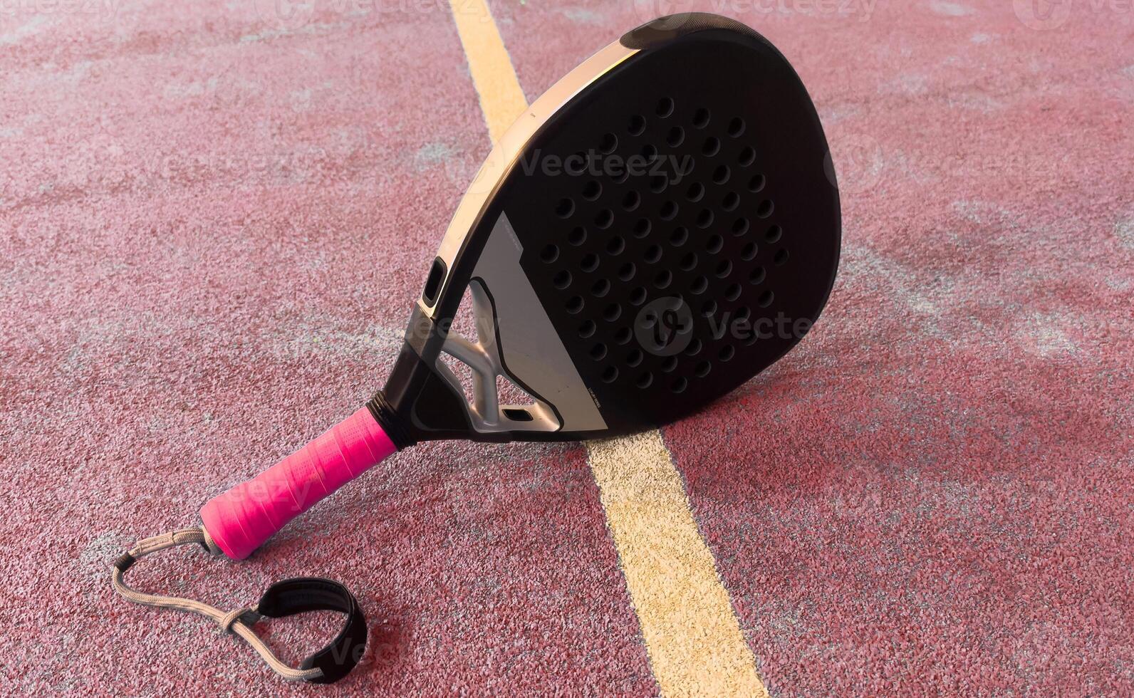 padel racket on a blue synthetic paddle tennis court photo