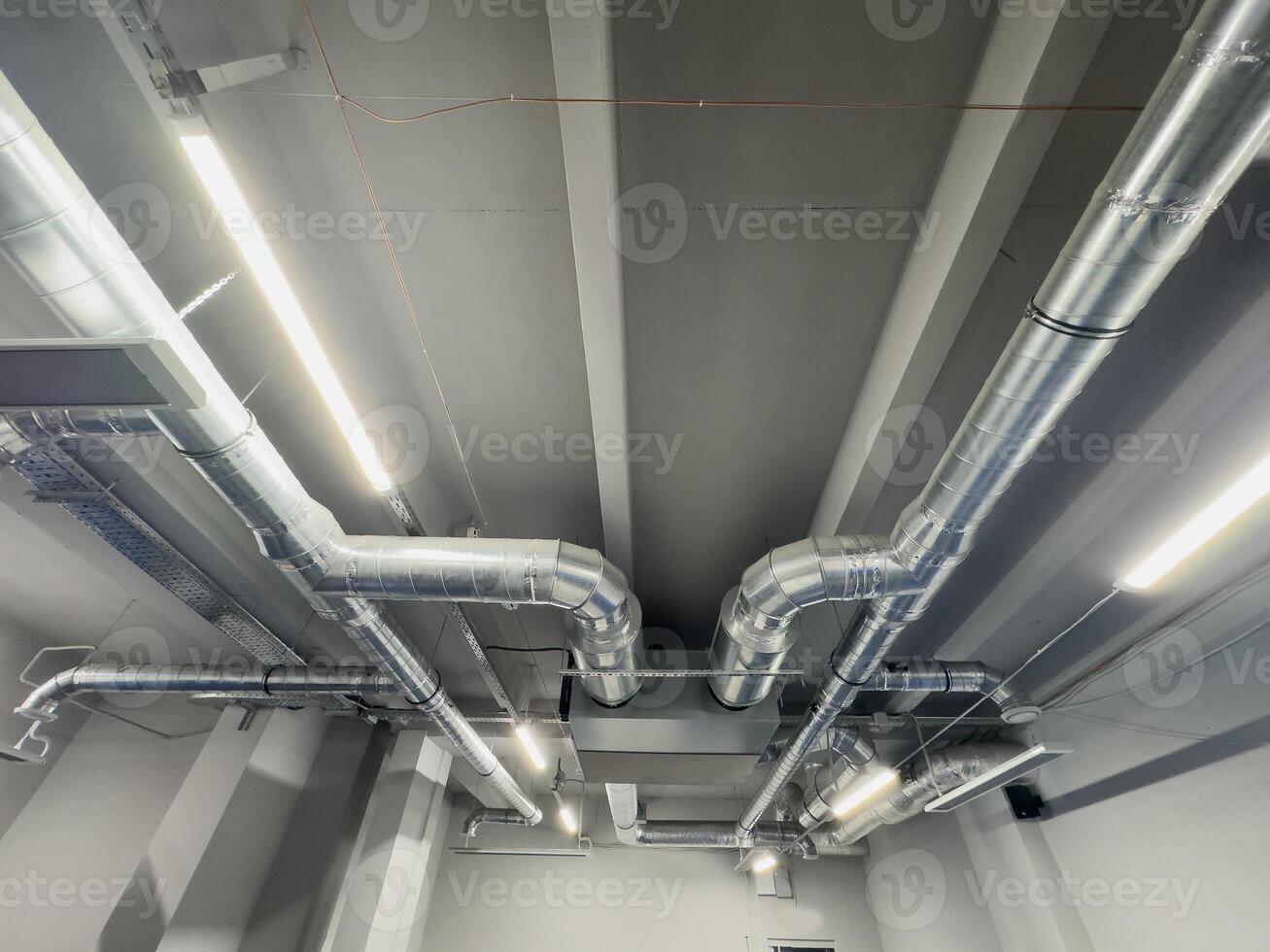 Metal pipes in thermal insulation winding on the ceiling of an industrial enterprise. photo