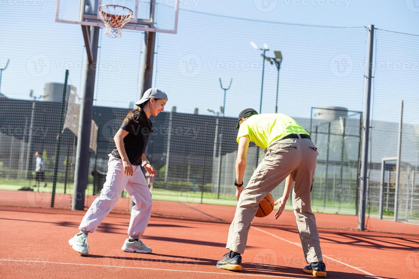 father and daughter playing basketball together on playground photo