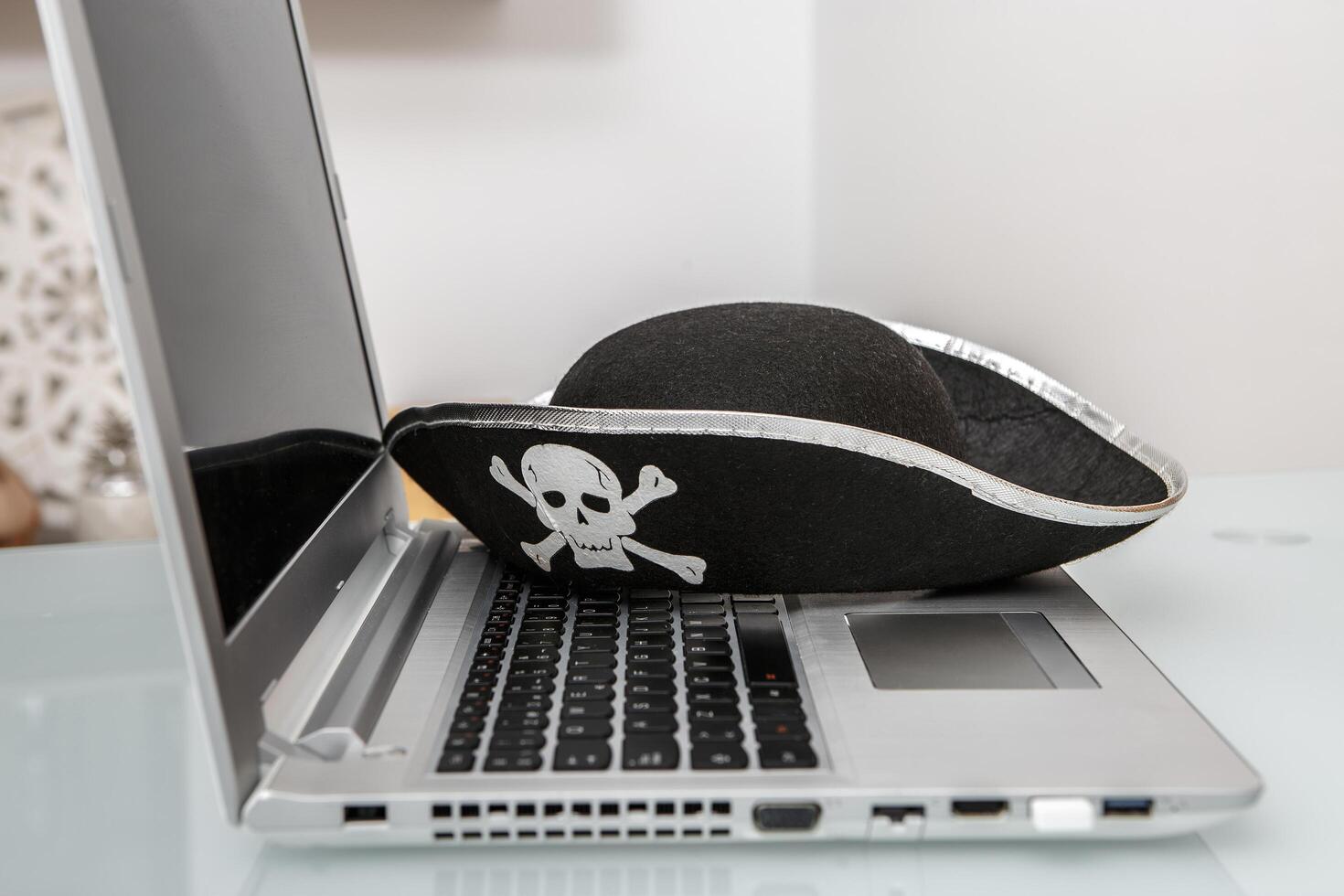 Creative Representation of Hacking and Online Scams With Pirate Hat on Laptop photo