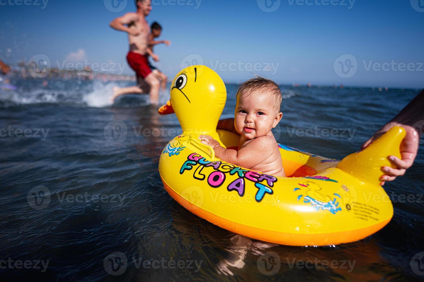 Baby girl enjoying a day at the beach in a yellow duck float with family photo