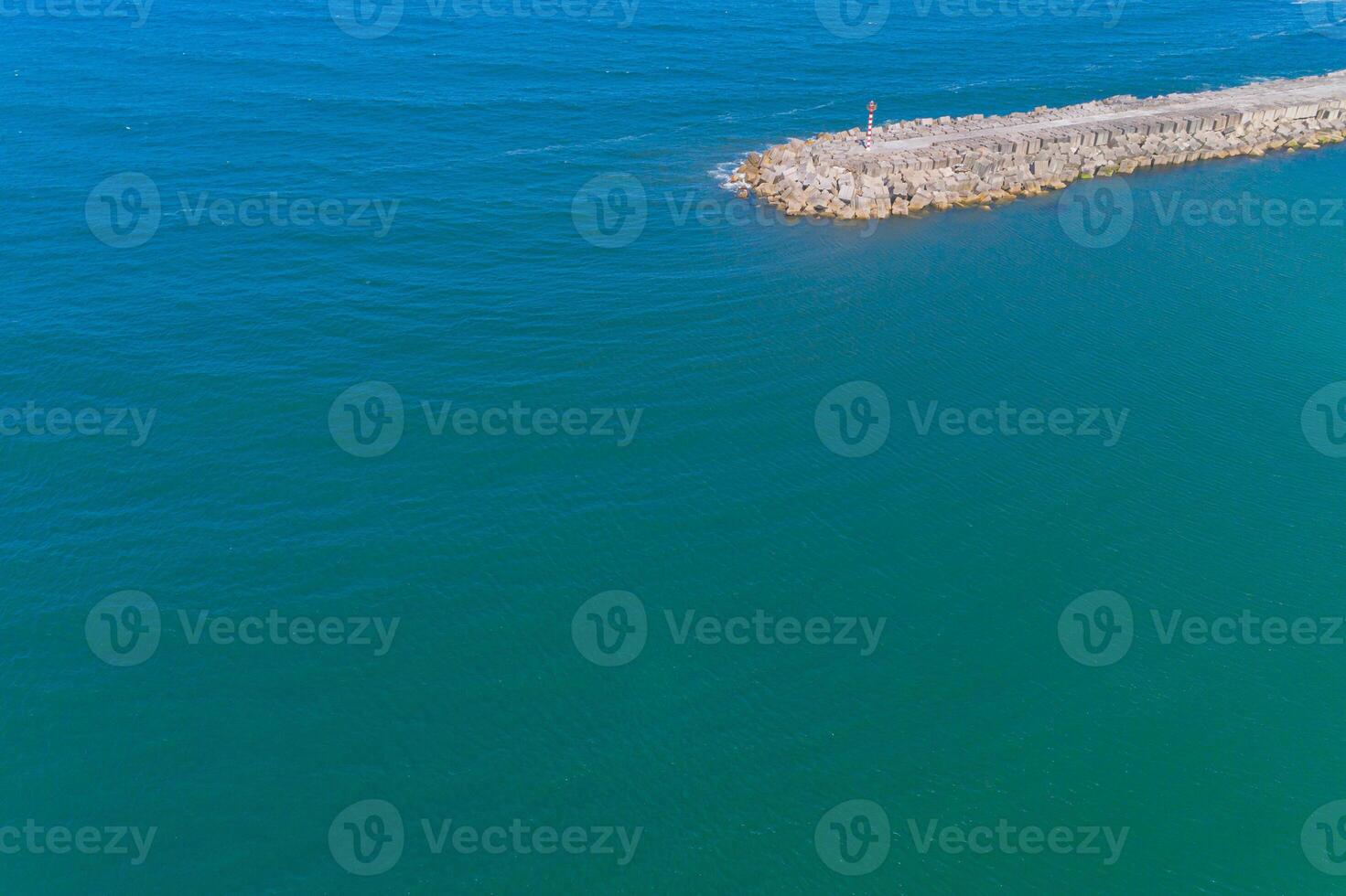 drone aerial view of a harbor breakwater on a calm sea day, summer time photo