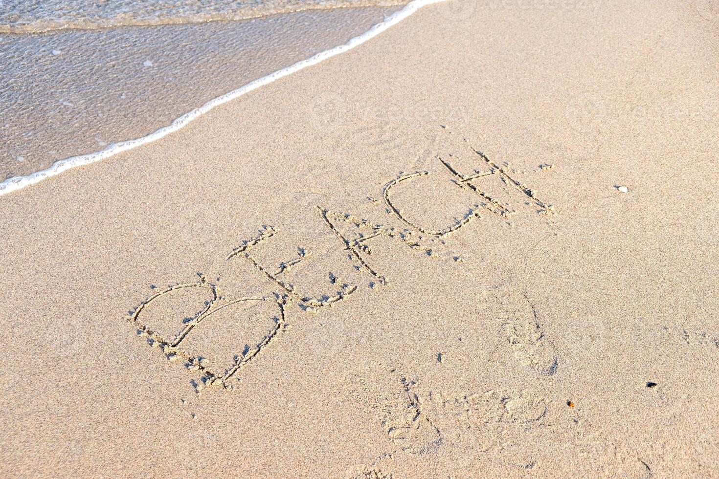 a beach shore with the word beach written on the sand photo