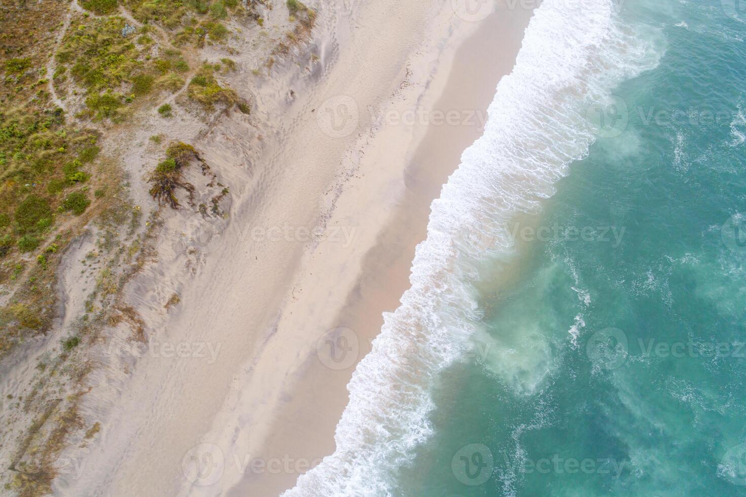 Spectacular top view from drone photo of beautiful beach with relaxing sunlight, sea water waves pounding the sand at the shore. Calmness and refreshing beach scenery