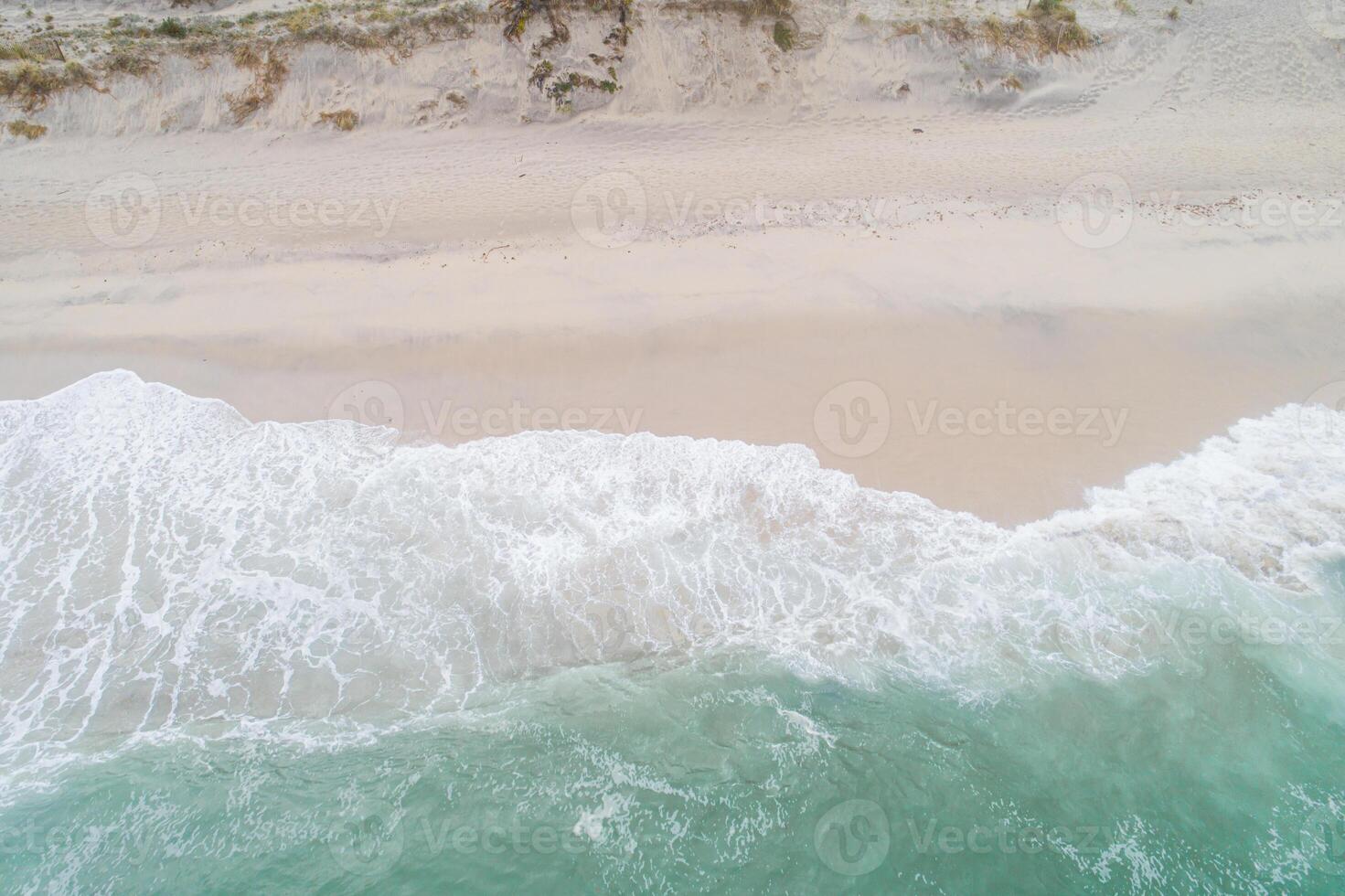 Summer seascape beautiful waves, blue sea water in sunny day. Top view from drone. Sea aerial view, amazing tropical nature background. Beautiful bright sea with waves splashing and beach sand concept photo