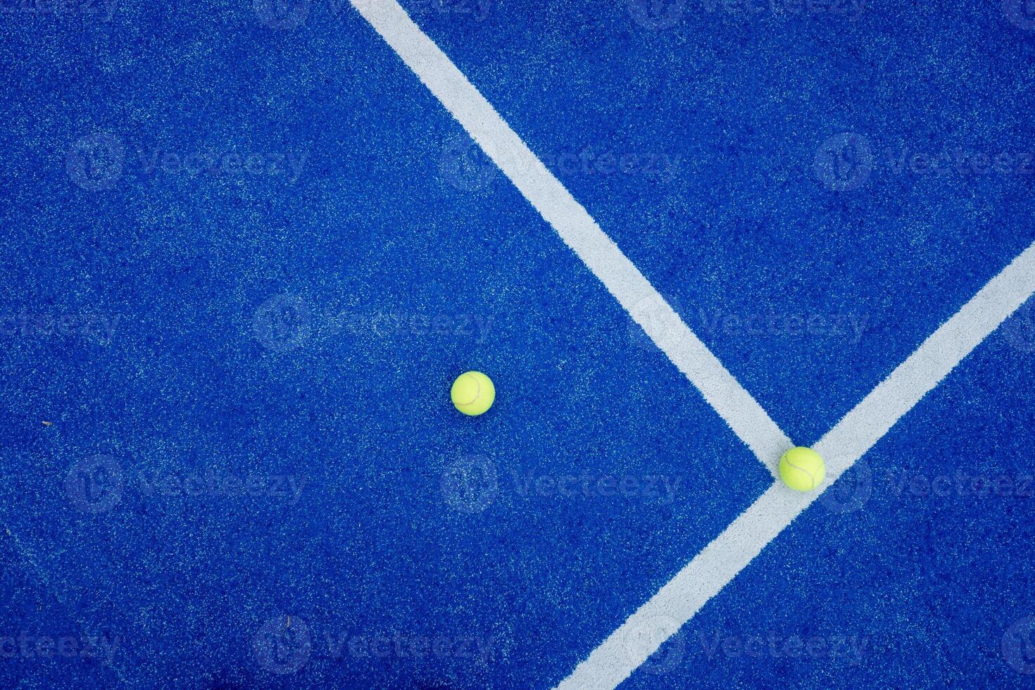 Top view of a line and texture of blue paddle tennis court and two yellow balls. Artificial grass paddle court ground. photo