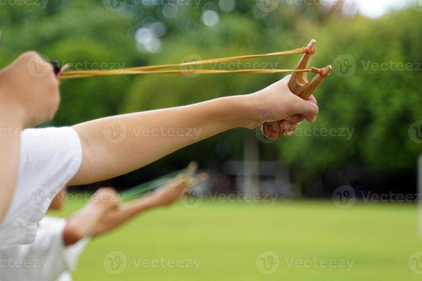 Boys compete with each other to shoot slingshots to hit the target, which is an ancient countryside activity for children in Thailand. photo