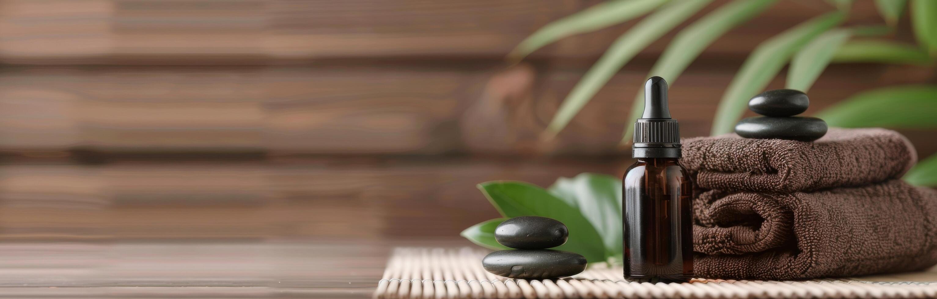 Essential Oil Bottle and Stones on Bamboo Mat in Relaxing Spa Setting photo