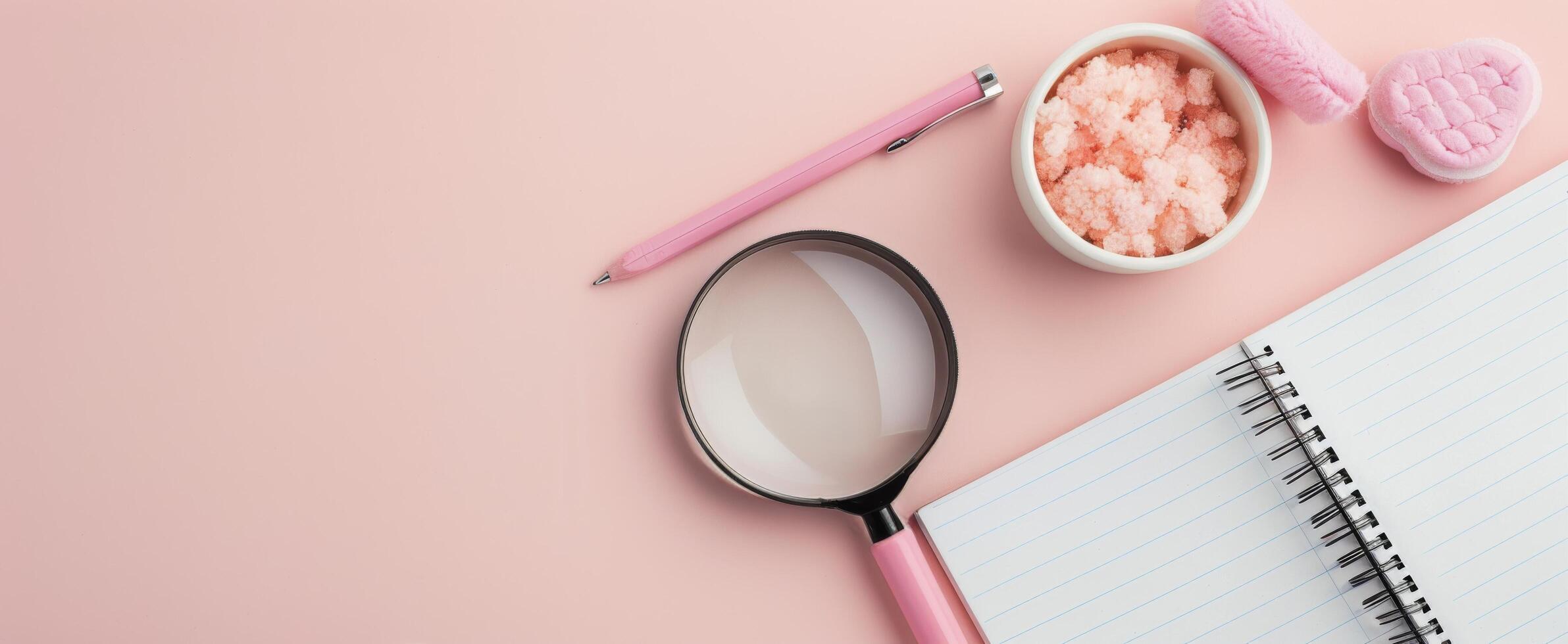 Magnifying Glass on Blank Notebook Surrounded by Neutral Background photo