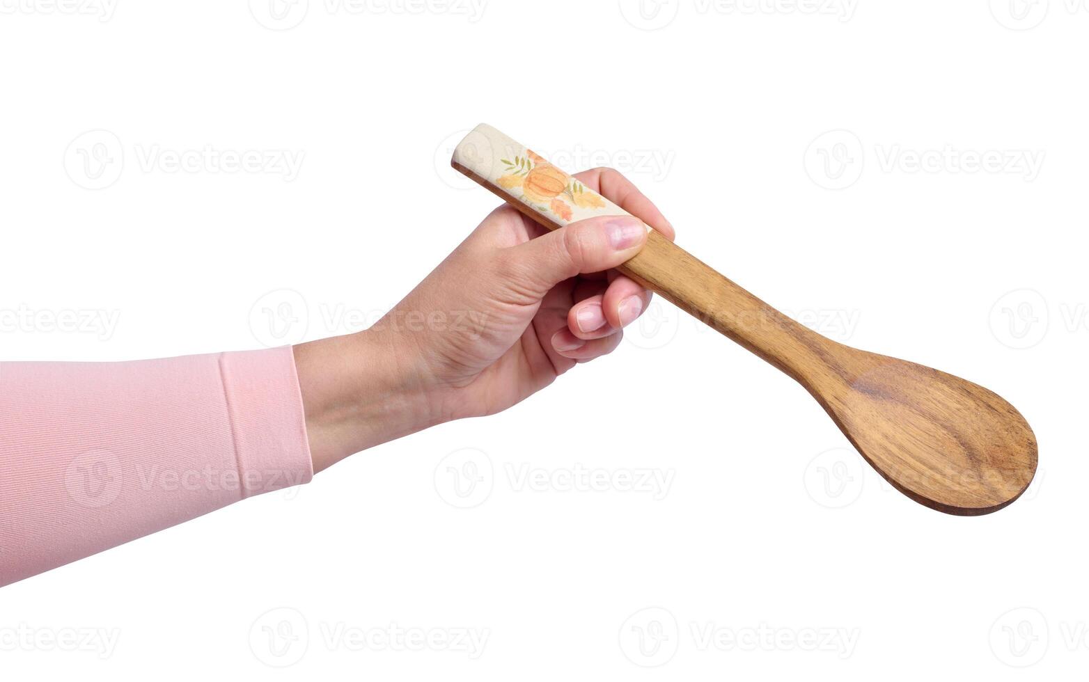 A woman's hand holds a wooden spoon on a white background photo