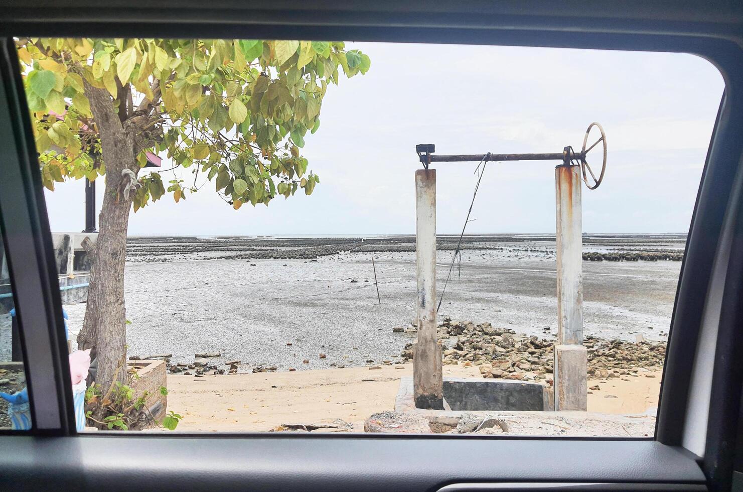 Looking through the car window, I saw the dam next to the sea. I saw the sea, the trees, the sky. photo