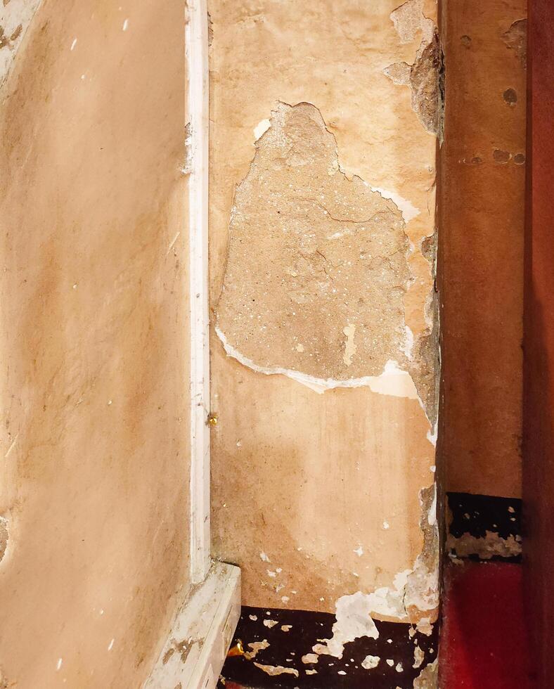 The cement walls of the church's pillars are cracked into strange patterns, giving a mystical look to the whole picture.Interior of abandoned and ruined house with broken wall. photo
